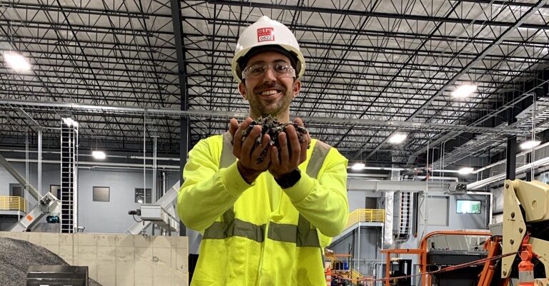 Man holding a handful of plastic pellets.